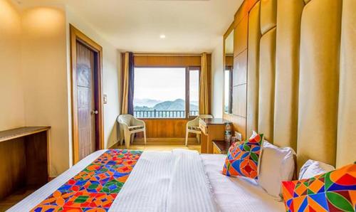 una camera da letto con un grande letto e una finestra di FabExpress Clock View 500M From The Mall Road a Mussoorie
