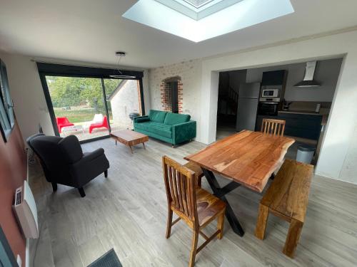 - un salon avec une table en bois et un canapé vert dans l'établissement Gîte Le Ballandeau, à Ballan-Miré