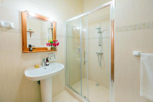 a bathroom with a glass shower and a sink at Veduta Holiday Home in Qala