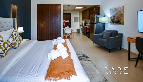 a hotel room with a bed with towels on it at Rare Holiday Homes - Close to Stadium - Canal View - Stadium Point - R811 - Dubai Sports City in Dubai