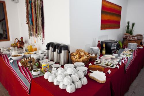 a long red table with food and dishes on it at Tierra Viva Cusco Centro in Cusco
