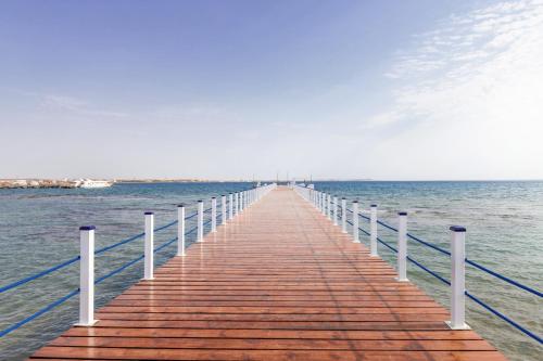 a wooden pier stretches out into the ocean at Pickalbatros Dana Beach Resort - Aqua Park in Hurghada