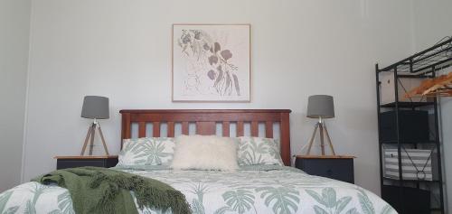 a bedroom with a bed and two lamps and a picture at Serenity Holiday House Port Lincoln Holiday House in Port Lincoln