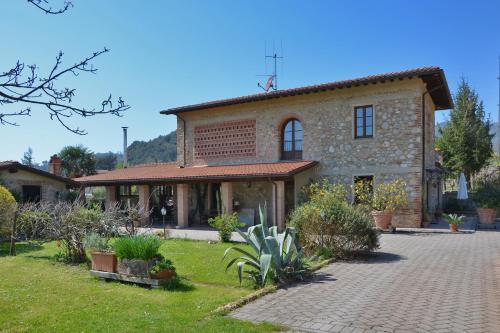 una gran casa de piedra con un jardín delante de ella en Casa Teresa - Happy Rentals, en Camaiore