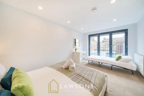 a white bedroom with a bed and a window at Watt a Stay I Free EV Parking in Windsor