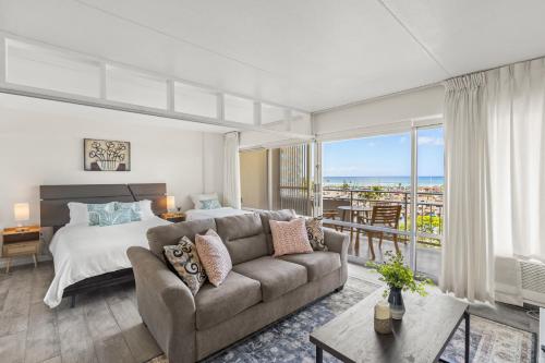 a bedroom with a couch and a bed with a view at Ilikai Hotel with Ocean View in Honolulu