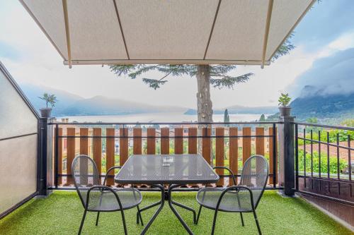 eine Terrasse mit Tisch und Stühlen auf einem Balkon in der Unterkunft Lake View CORI Apartments in Menaggio