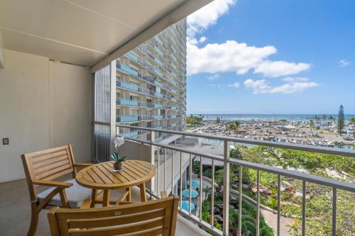 a balcony with a table and chairs and a view of the city at Ilikai Hotel with Ocean View in Honolulu