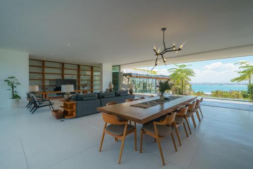 ein Wohnzimmer mit einem Esstisch und einem großen Fenster in der Unterkunft Beyond The Sea - Luxe Sea View Villa in Jimbaran in Jimbaran