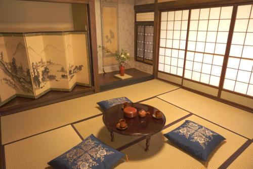 a room with a table and pillows in a room with windows at Aioi Yanto 一日一組限定古民家宿 in Otaru