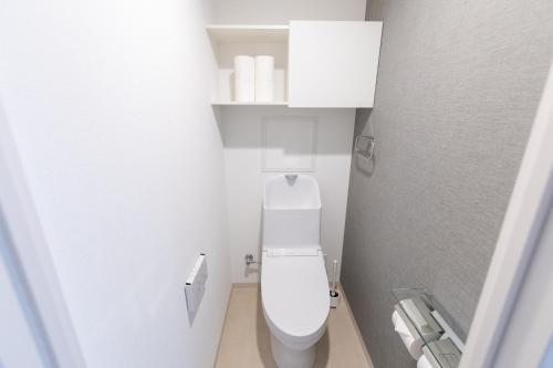 a small bathroom with a white toilet in a room at Ocean Tsutenkaku in Osaka