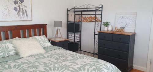 a bedroom with a bed and a dresser at Serenity Holiday House Port Lincoln Holiday House in Port Lincoln