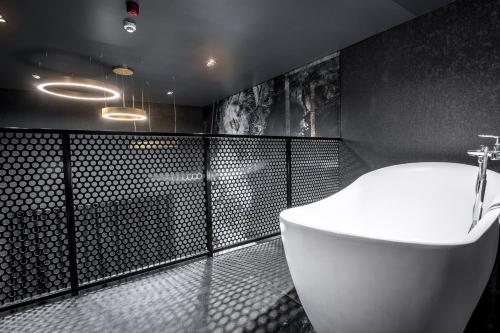 ein Badezimmer mit einem weißen WC und einer schwarzen Wand in der Unterkunft Black Hotels Köln in Köln