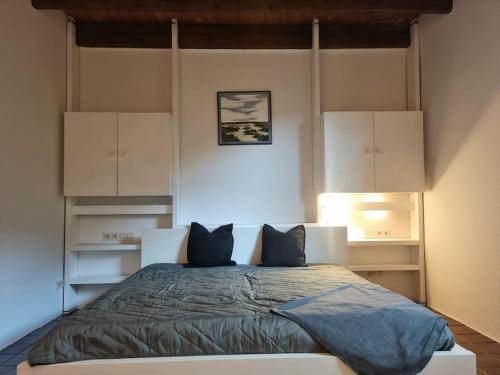 Großzügiges Ferienhaus im Grünen في فيلهلمسهافن: غرفة نوم بسرير كبير مع دواليب بيضاء