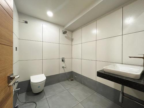 a bathroom with a toilet and a sink at Antarim Express in Bharuch