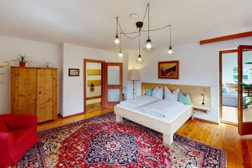 a bedroom with a bed and a red chair at Haus Alberto - Haus mit 2 Ferienwohnungen in Ötztal-Bahnhof
