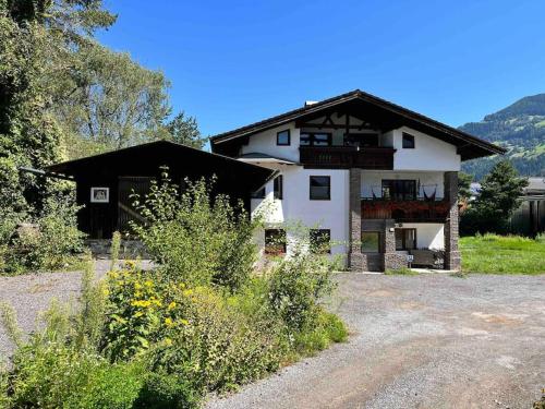 a large white house with a black roof at Haus Alberto - Haus mit 2 Ferienwohnungen in Ötztal-Bahnhof