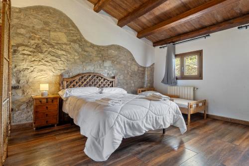 a bedroom with a large bed and a stone wall at Can tronc in Querol