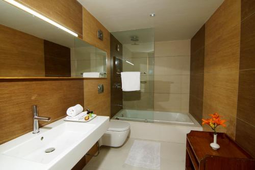 a bathroom with a sink and a toilet and a tub at Banon Resorts in Manāli