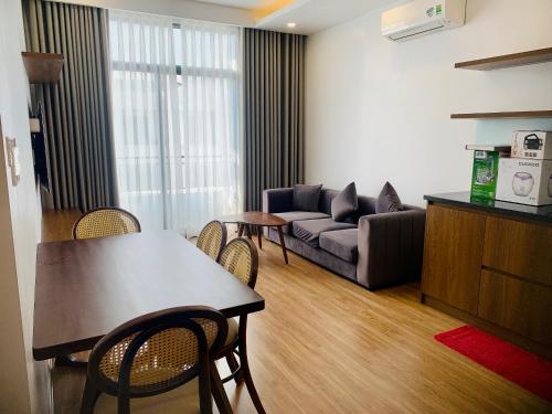 a living room with a couch and a table and chairs at V-Homestay in Hai Phong