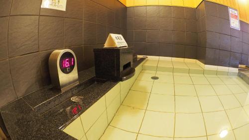 a bathroom with a urinal on a tiled floor at Castle Inn Toyokawa in Toyokawa
