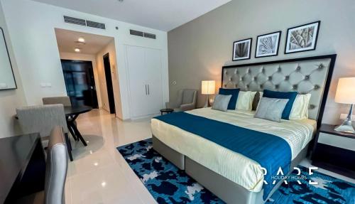 a bedroom with a large bed and a desk at Rare Holiday Homes - Spacious apartment - Near Expo City - Dubai South - R410 in Dubai