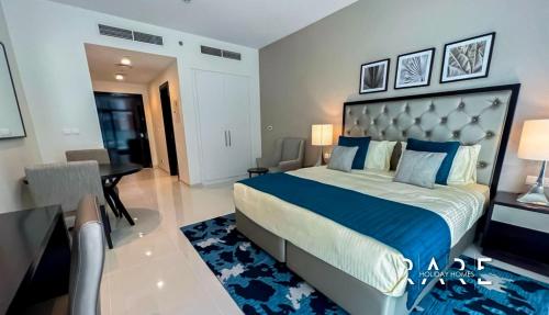 a bedroom with a large bed and a desk at Spacious Studio APT - Near Expo 2020 - Dubai South R410 in Dubai