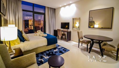 Habitación de hotel con cama, mesa y sillas en Rare Holiday Homes offers Luxurious apartment with desert View - Near Expo City - R451 en Dubái