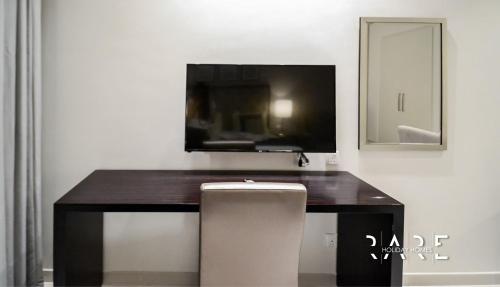 a desk with a television and a chair in a room at Pool View - Near Expo 2020 - Ultra Modern Studio in Dubai