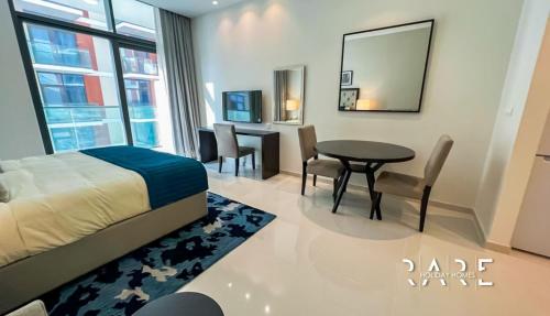 a bedroom with a bed and a table and chairs at Pool View - Near Expo 2020 - Ultra Modern Studio in Dubai