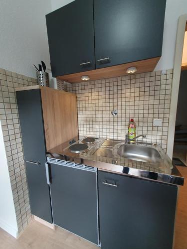 a kitchen with a sink and a stainless steel refrigerator at Appartement im Herzen von Langenberg in Velbert