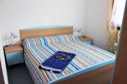 1 cama con manta azul y 2 mesitas de noche en Poolside escape in Rosolina mare - Beahost, en Rosapineta