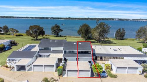 une vue aérienne sur une maison avec un lac en arrière-plan dans l'établissement Paradise On Pumicestone Passage, à Sandstone Point