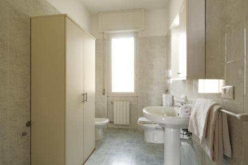 a white bathroom with a sink and a toilet at Residence i Cormorani in Loano