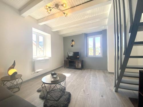 a living room with a staircase and a table at Le P'tit Rupt Refuge cocooning in Rupt-sur-Moselle