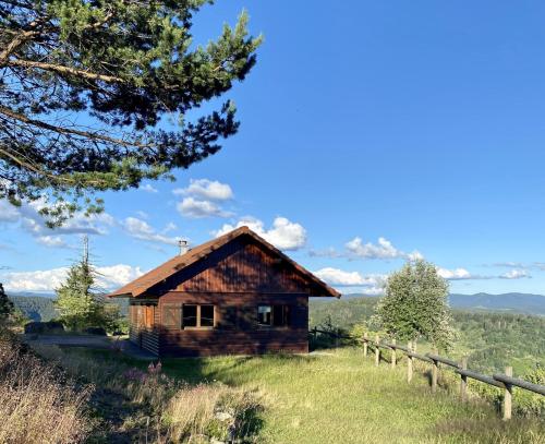 a log cabin on a hill with a fence at Le P'tit Rupt Refuge cocooning in Rupt-sur-Moselle