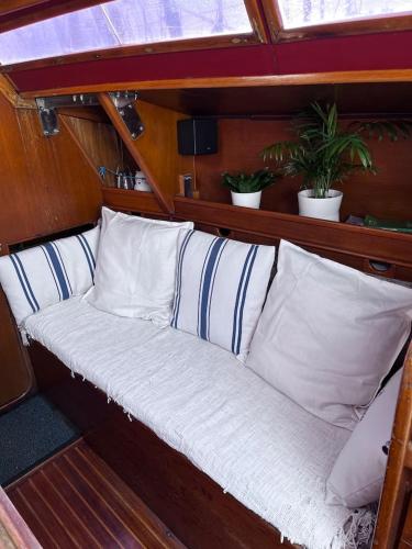 a bench in the back of a boat with pillows at Dejaté acunar por nuesto velero in Sitges
