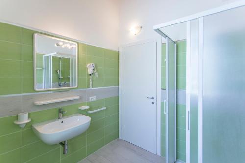 een badkamer met een wastafel en een spiegel bij Altanea Apartments con piscina in Caorle