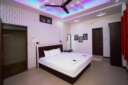 Hotel Elite Lodging and Restaurant في بانغالور: غرفة نوم بسرير كبير مع مروحة سقف