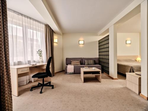 ワルシャワにあるApartamenty Media Parkのベッドとデスクが備わるホテルルームです。