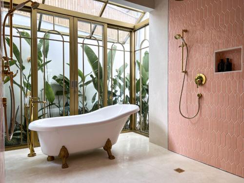 a bath tub in a bathroom with plants at No Rush Villas in Canggu