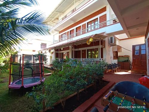 a house with a playground in the yard at Redstone House by Oxystays Hospitality in Ganpatipule