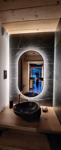 a bathroom with a large black tub in front of a mirror at Les Deltas du Lac in Chambon-sur-Lac