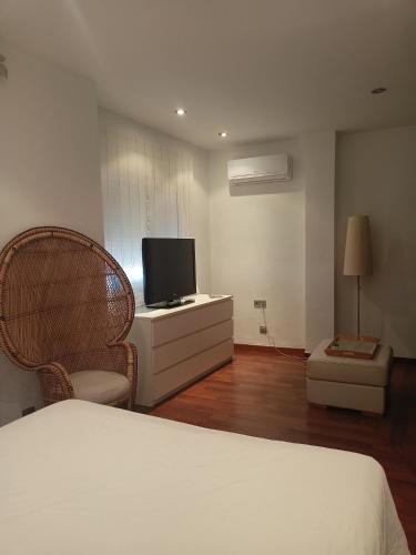 a bedroom with a bed and a tv and chairs at Habitación con vistas in Aguadulce