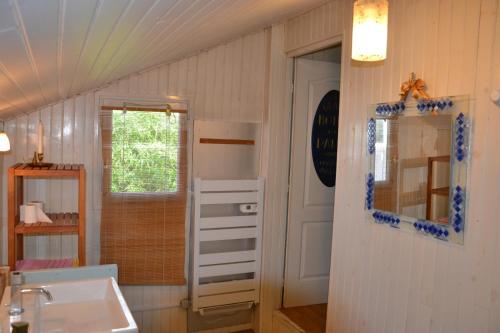ein Badezimmer mit einem Waschbecken, einem Spiegel und einer Tür in der Unterkunft maison atypique cosy Disneyland Paris/la vallée village/parking in Esbly