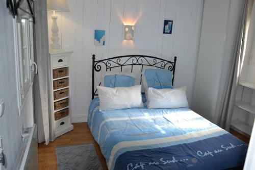 Schlafzimmer mit einem Bett mit blauer Bettwäsche und weißen Kissen in der Unterkunft maison atypique cosy Disneyland Paris/la vallée village/parking in Esbly