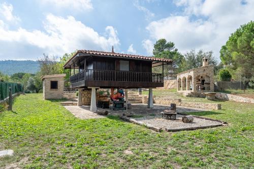 a house with a balcony and a fire pit in a field at Horrio in Querol