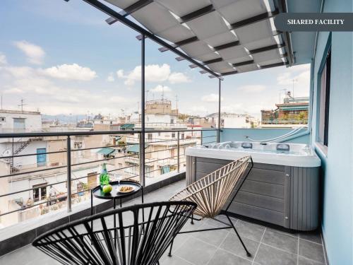 雅典的住宿－Sanders Home Suites，阳台配有浴缸和桌椅。