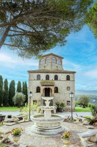 a large stone building with a fountain in front of it at I Segreti del Borgo in Penna in Teverina