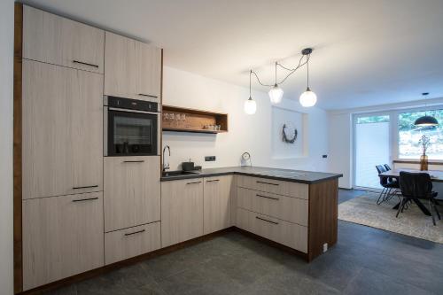 eine Küche mit Holzschränken, einem Tisch und einem Esszimmer in der Unterkunft Apartments Vorhöfe in Morter